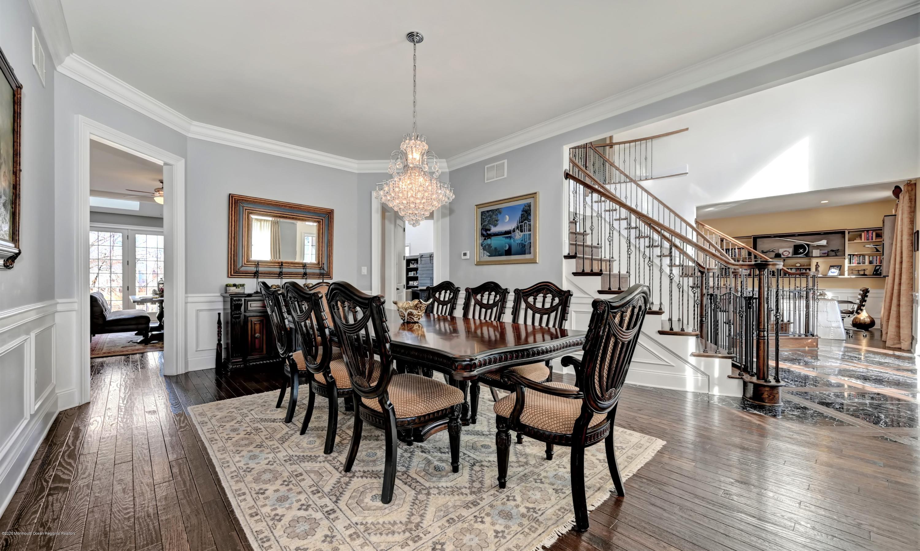 15 Windermere Road Lincroft, NJ 07738 - Photo 16 of 56 a view of a dining room and livingroom with furniture wooden floor a rug a chandelier and a mirror