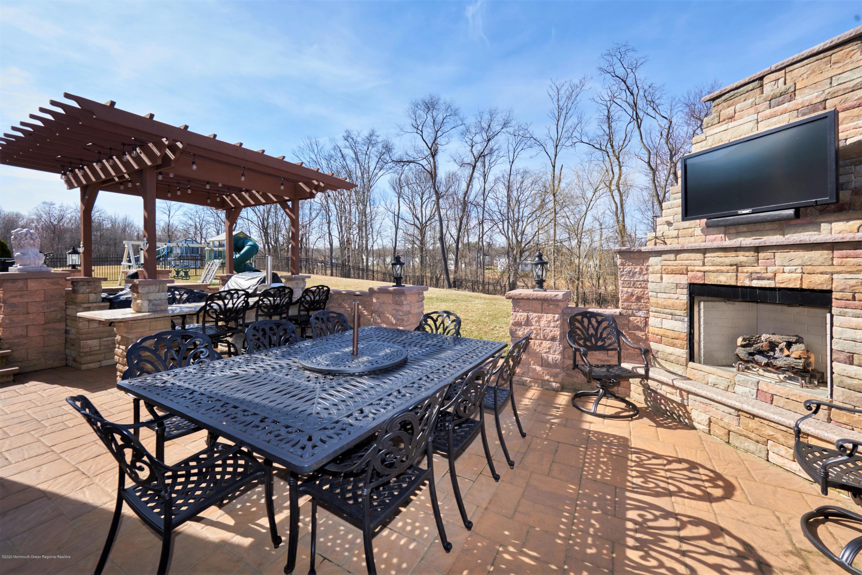 15 Windermere Road Lincroft, NJ 07738 - Photo 46 of 56 a wooden table and chairs with the umbrella in the patio