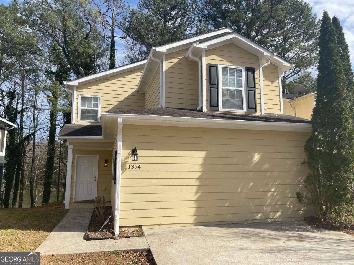 1374 To Lani Farm Road Stone Mountain, GA 30083 - Photo 1 of 18 a front view of a house with a garage