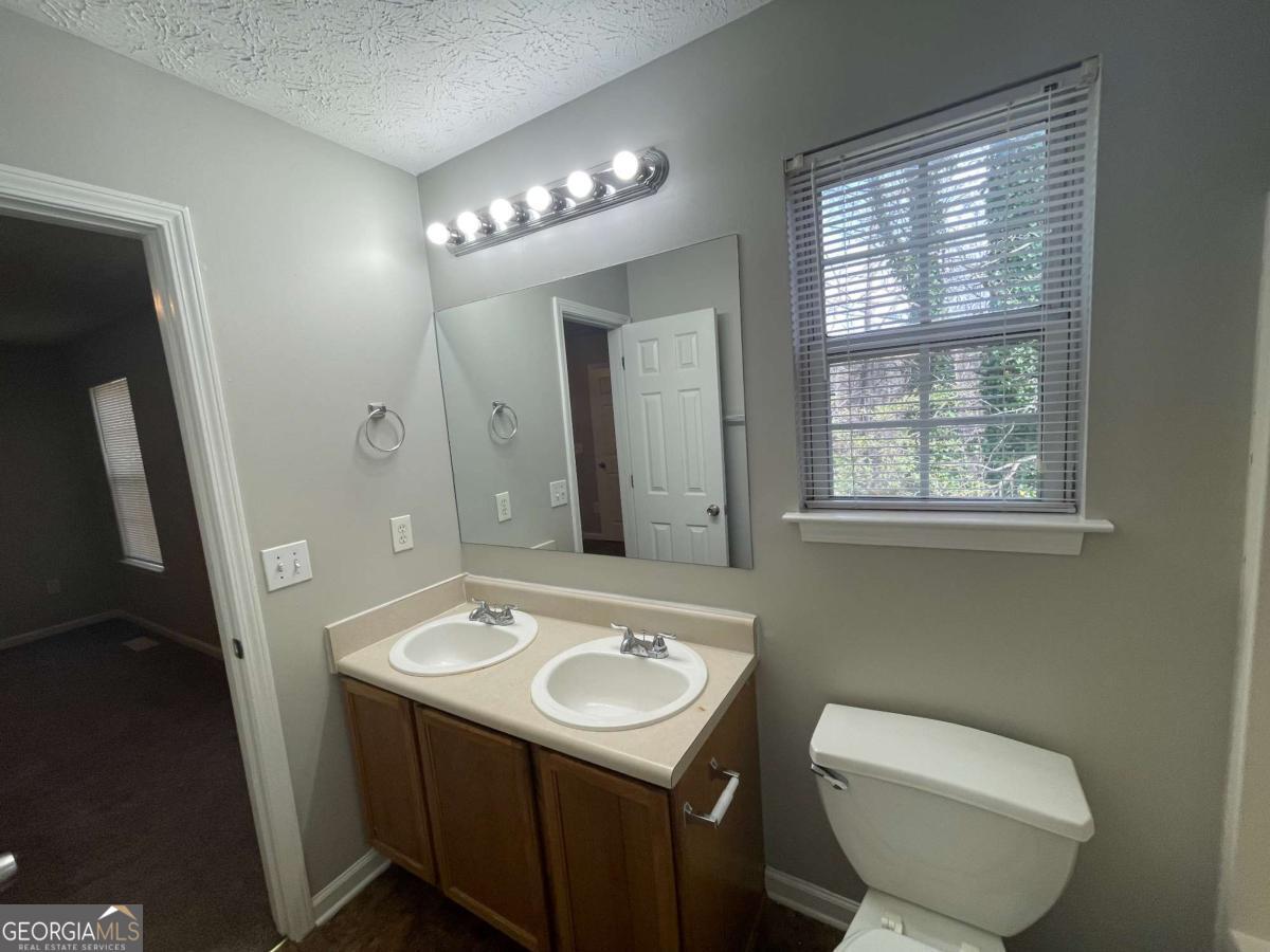 1374 To Lani Farm Road Stone Mountain, GA 30083 - Photo 12 of 18 a bathroom with a toilet sink and mirror