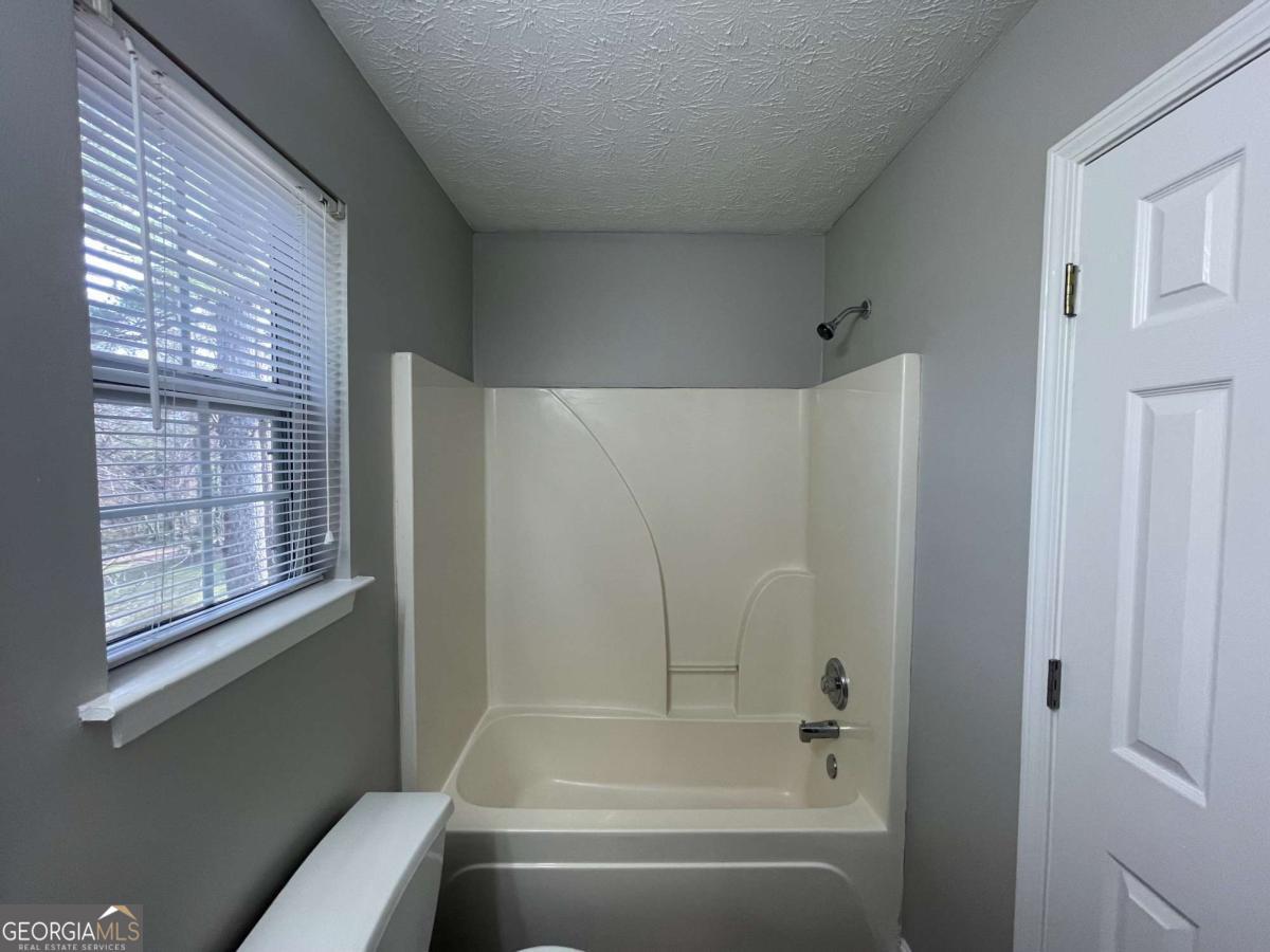 1374 To Lani Farm Road Stone Mountain, GA 30083 - Photo 13 of 18 a bathroom with a bathtub and a shower