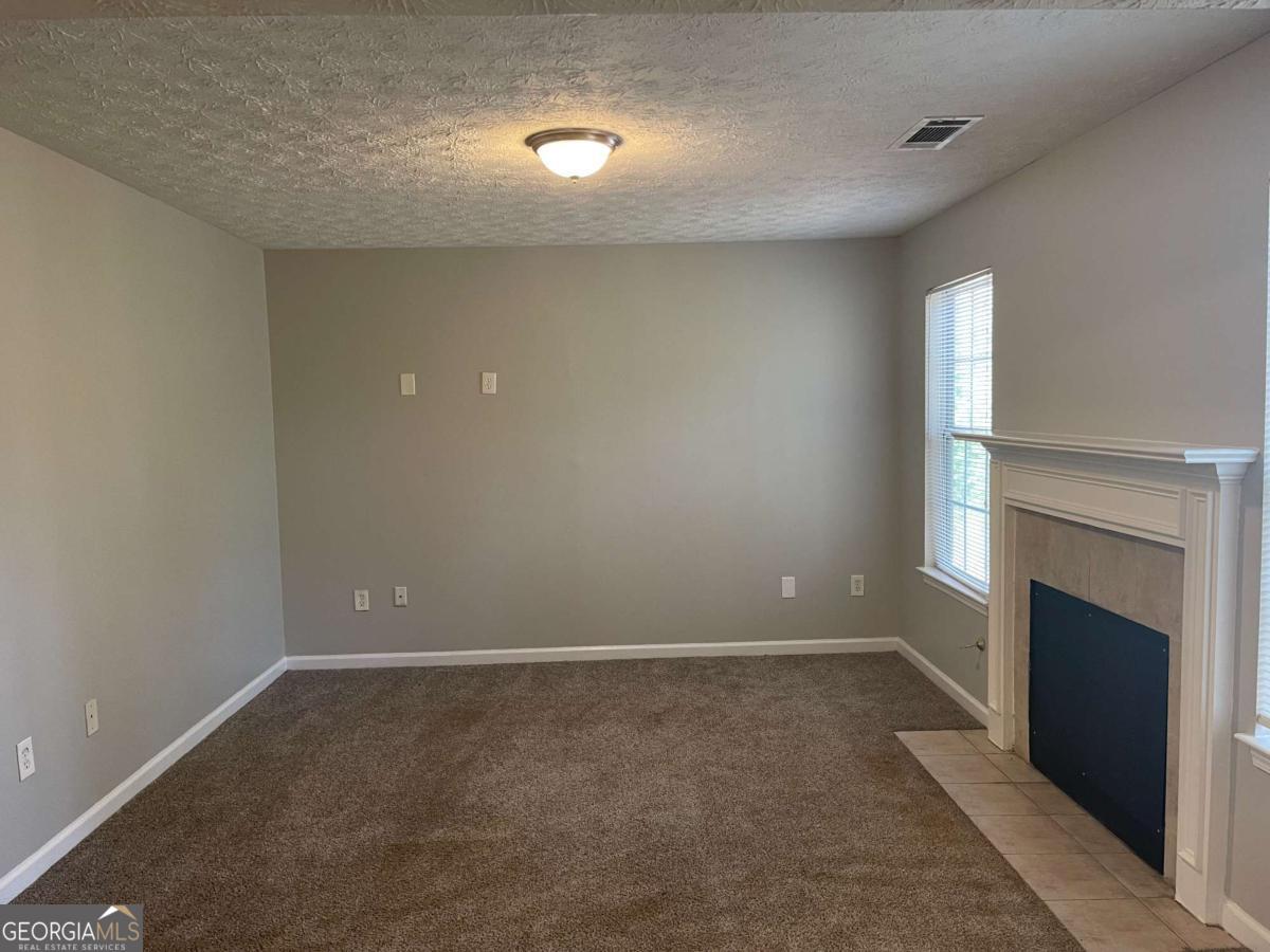 1374 To Lani Farm Road Stone Mountain, GA 30083 - Photo 2 of 18 a view of room with a ceiling fan and window