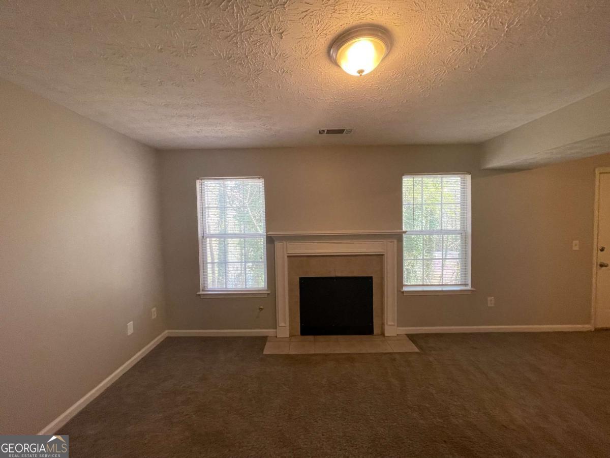 1374 To Lani Farm Road Stone Mountain, GA 30083 - Photo 3 of 18 an empty room with windows and fireplace