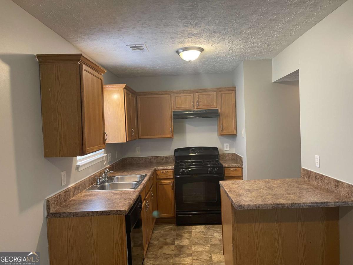 1374 To Lani Farm Road Stone Mountain, GA 30083 - Photo 7 of 18 a kitchen with a stove and a sink