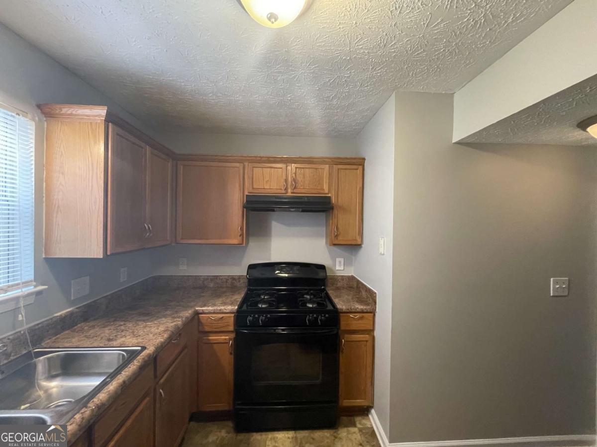 1374 To Lani Farm Road Stone Mountain, GA 30083 - Photo 8 of 18 a kitchen with a sink and a stove