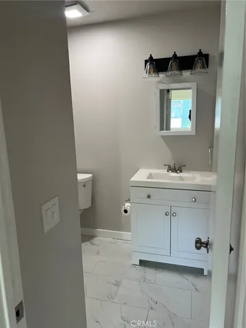 a bathroom with a sink toilet and mirror