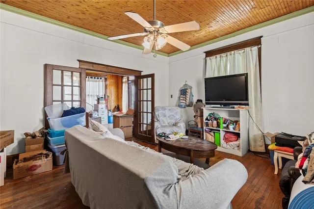 a living room with furniture a flat screen tv and a floor to ceiling window