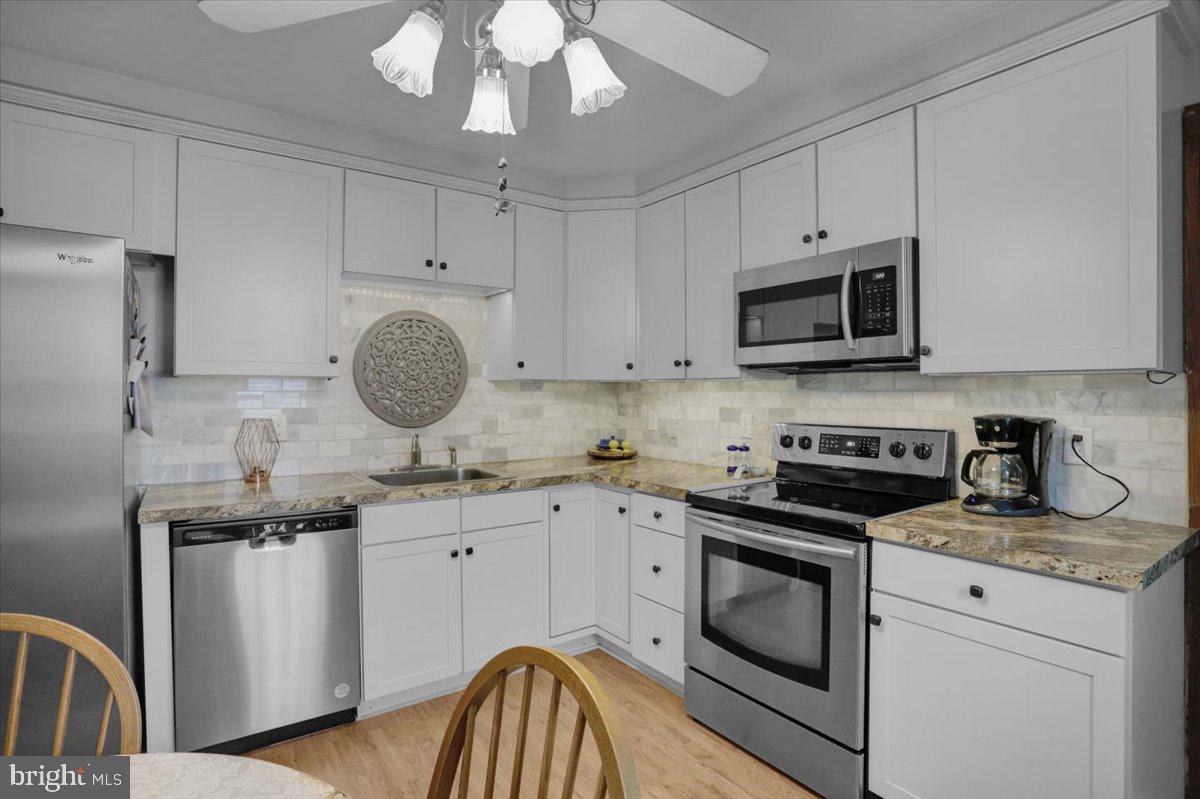1322 Brooke Boulevard Reading, PA 19607 - Photo 11 of 36 a kitchen with granite countertop a sink stainless steel appliances and white cabinets