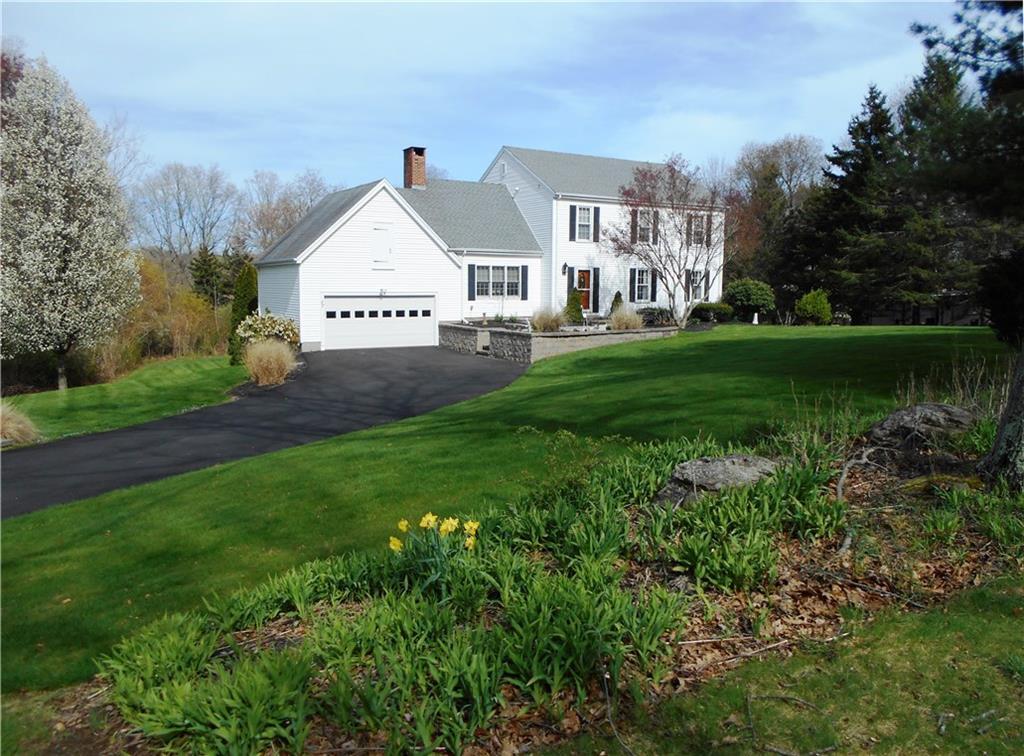 a view of a house next to a big yard and large trees