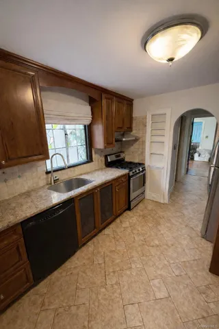 a kitchen with stainless steel appliances granite countertop a sink stove and refrigerator