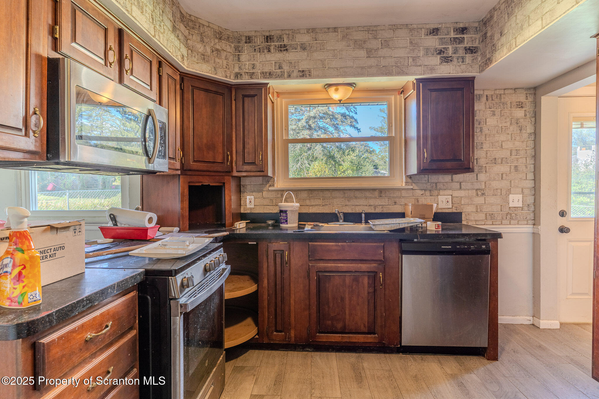 101 Sunset Road Dalton, PA 18414 - Photo 12 of 37 a kitchen with stainless steel appliances granite countertop a stove a sink dishwasher and a microwave oven with large wooden cabinets