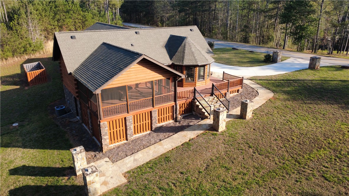 128 McAlister Road West Union, SC 29696 - Photo 37 of 40 A charming log cabin with a stone pathway, screened porch, and spacious outdoor deck awaits.