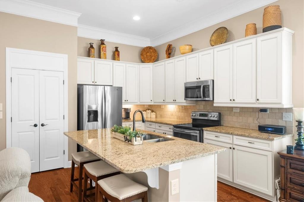 3880 Sweet Magnolia Drive Southwest Gainesville, GA 30504 - Photo 17 of 56 a kitchen with stainless steel appliances granite countertop a stove a refrigerator a sink a dining table and chairs with white countertops