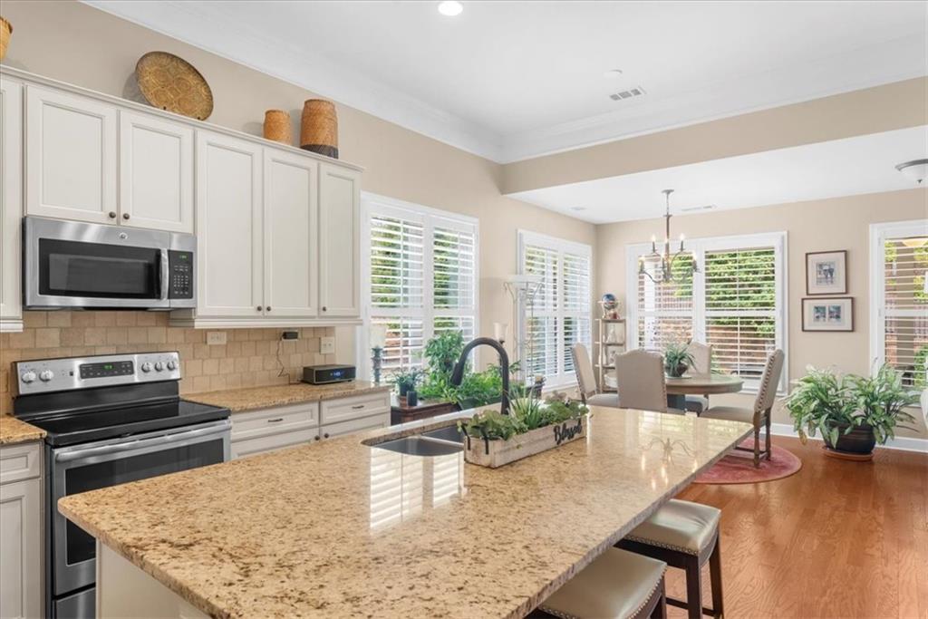 3880 Sweet Magnolia Drive Southwest Gainesville, GA 30504 - Photo 18 of 56 a kitchen with a stove a sink and a white cabinets