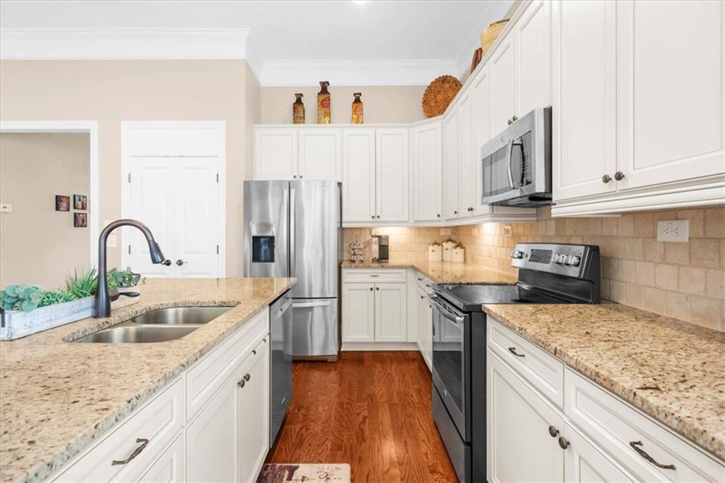 3880 Sweet Magnolia Drive Southwest Gainesville, GA 30504 - Photo 19 of 56 a kitchen with granite countertop a sink stainless steel appliances and cabinets