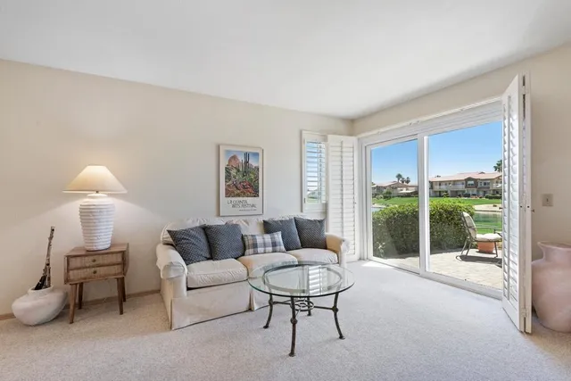 a living room with furniture and a large window with balcony view