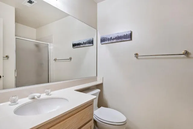 a bathroom with a sink mirror vanity and toilet