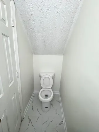a bathroom with a granite countertop toilet and a sink