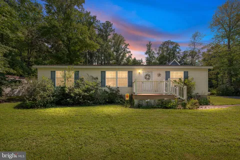 a view of a house with garden and trees