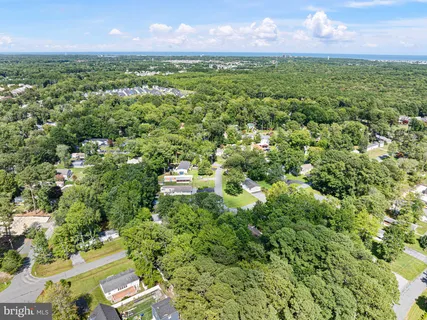 an aerial view of a houses with a yard and lake view