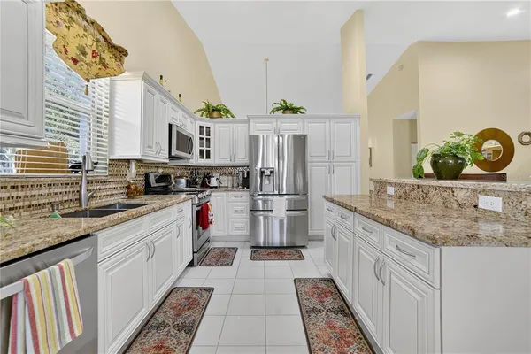 a kitchen with stainless steel appliances granite countertop a stove a sink and a refrigerator