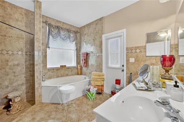 a bathroom with a tub sink and mirror