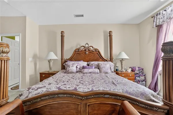 a bedroom with a bed and a dresser with mirror