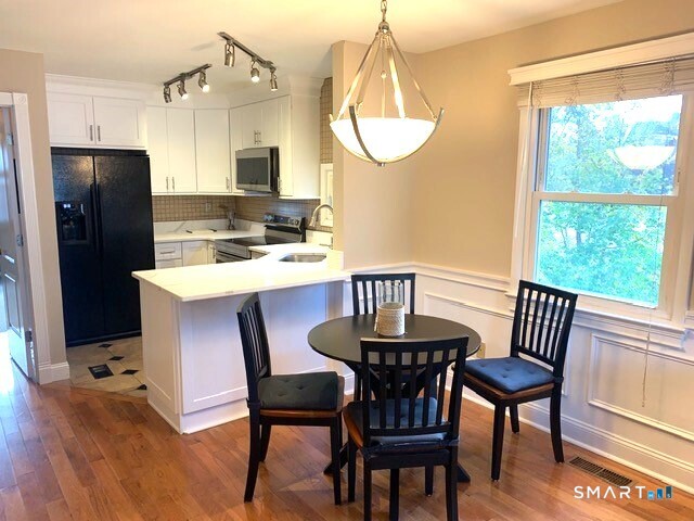 65 Ellsworth Street, Unit 302 Bridgeport, CT 06605 - Photo 12 of 40 a view of a dining room with furniture window and wooden floor