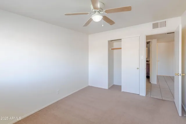 an empty room with a ceiling fan and a ceiling fan