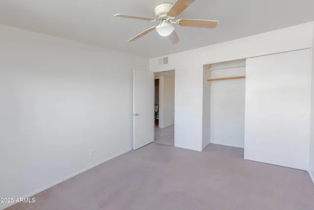 an empty room with a ceiling fan and a ceiling fan