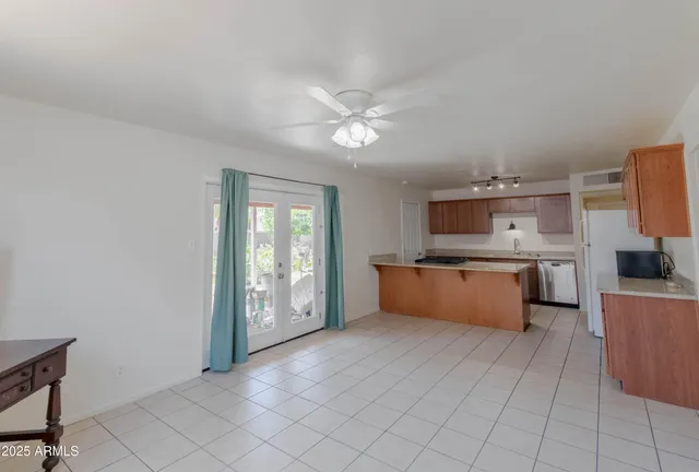 a large kitchen with stainless steel appliances granite countertop a large counter top a stove and a chandelier