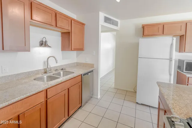 a kitchen with a sink refrigerator and cabinets