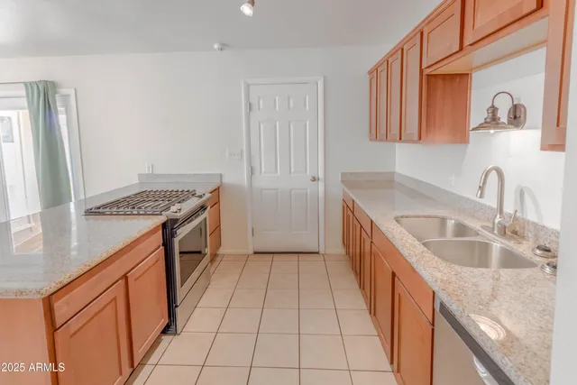 a kitchen with stainless steel appliances granite countertop a sink and a stove