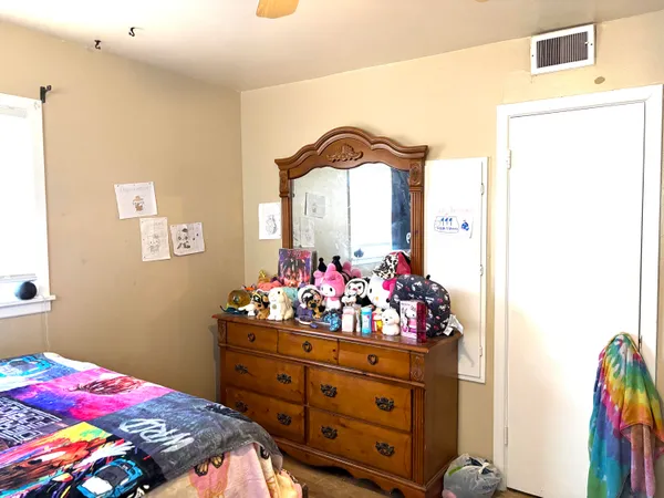 a bedroom with a bed and a dresser in it