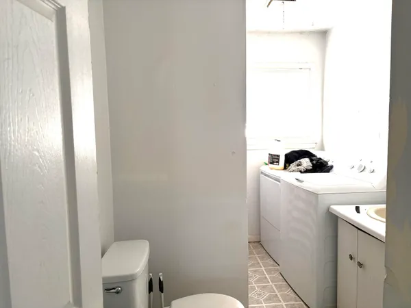 a bathroom with a toilet a sink and a window