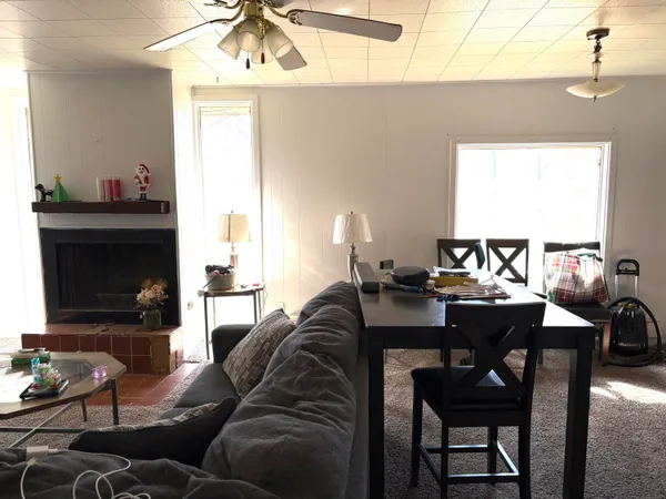a living room with furniture a fireplace and a window