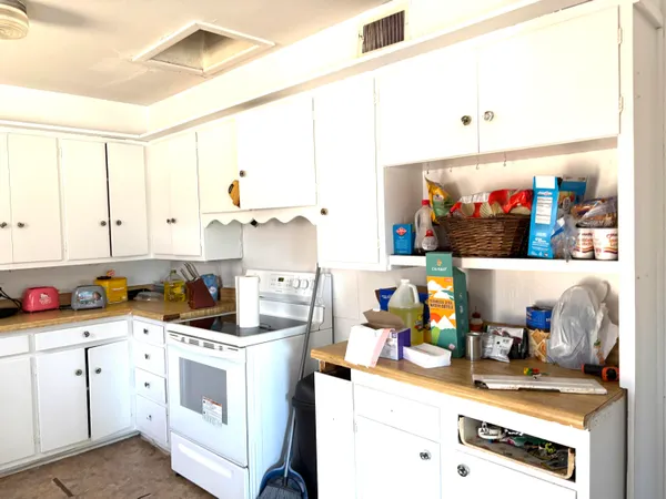 a kitchen with a stove a sink and cabinets