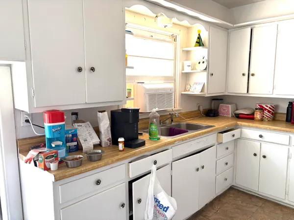 a room with kitchen island a sink cabinets and window