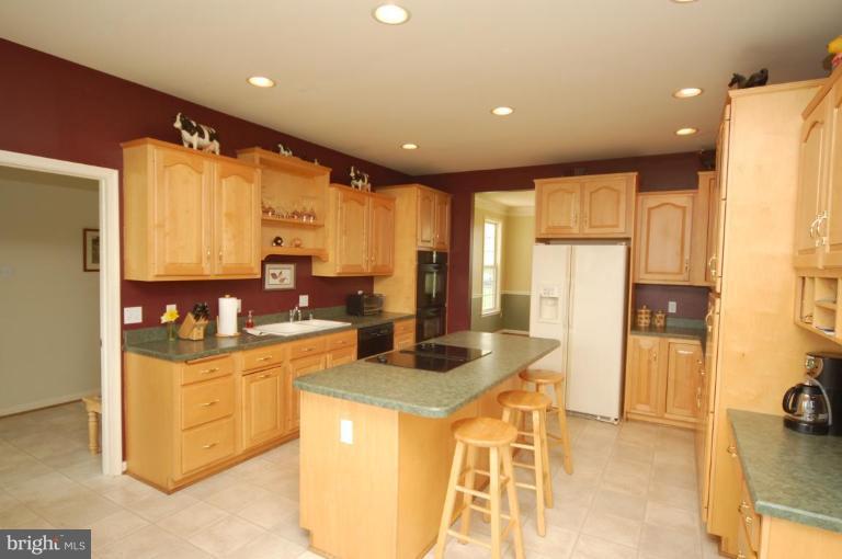 7791 Dollyhyde Road Mount Airy, MD 21771 - Photo 5 of 16 a kitchen with stainless steel appliances granite countertop a stove a sink and a refrigerator