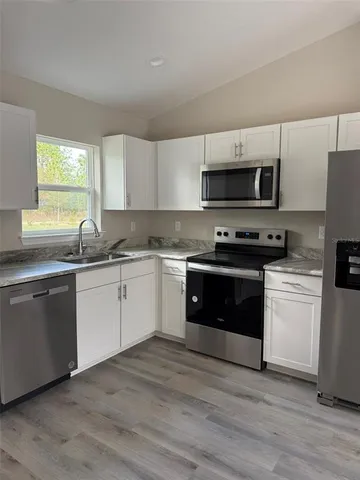 a kitchen with stainless steel appliances a stove a sink and a microwave