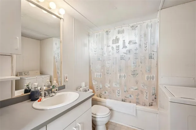 a bathroom with a sink a toilet and shower curtain