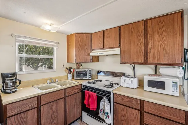 a kitchen with stainless steel appliances granite countertop a sink stove and cabinets