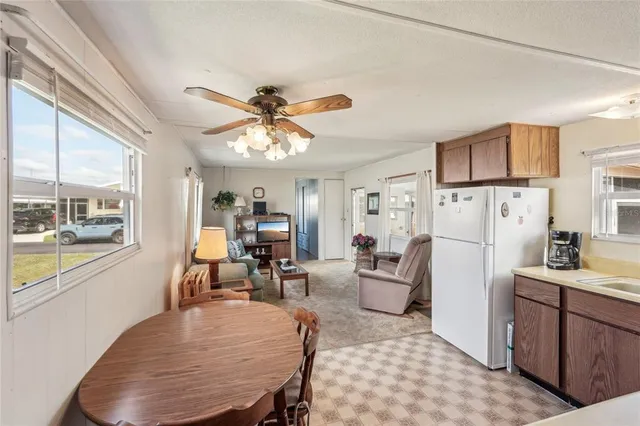 a living room with furniture a dining table and kitchen view