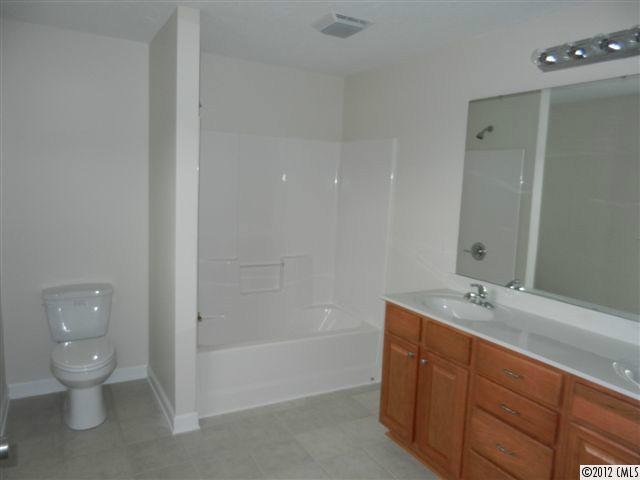 7595 Woodleaf Road Woodleaf, NC 27054 - Photo 11 of 16 a bathroom with a granite countertop sink a toilet and shower