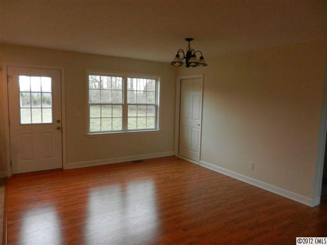 7595 Woodleaf Road Woodleaf, NC 27054 - Photo 6 of 16 an empty room with wooden floor and windows