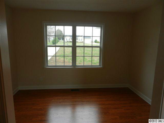 7595 Woodleaf Road Woodleaf, NC 27054 - Photo 7 of 16 a view of an empty room with wooden floor and a window