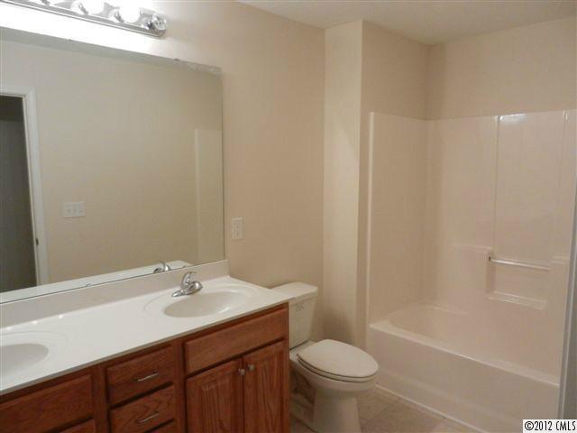 7595 Woodleaf Road Woodleaf, NC 27054 - Photo 9 of 16 a bathroom with a sink a toilet and shower