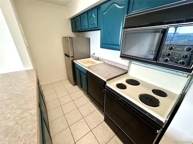 a kitchen with a refrigerator and a stove top oven