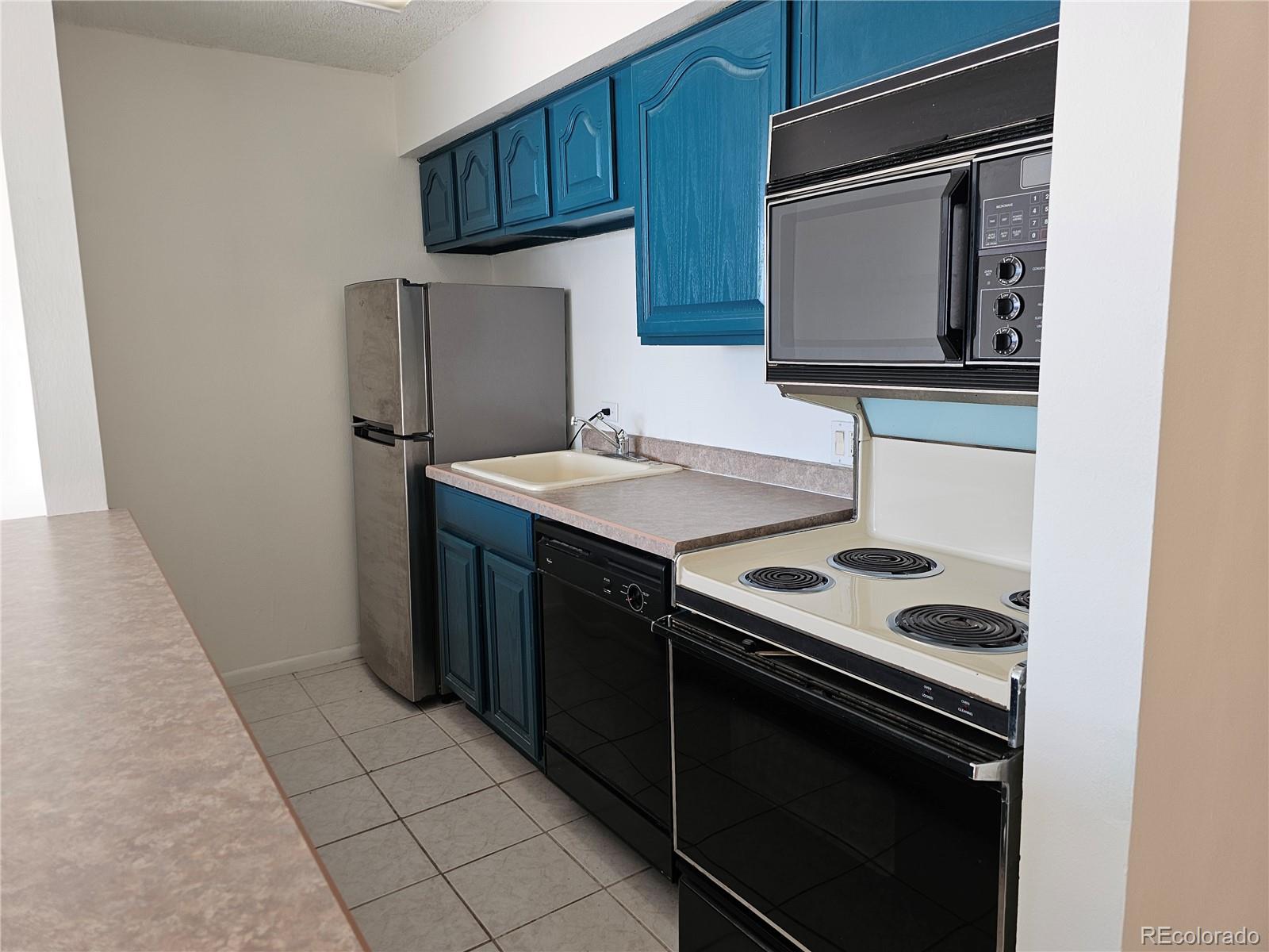 1020 15th Street, Unit 33B Denver, CO 80202 - Photo 16 of 48 a kitchen with a stove microwave and sink