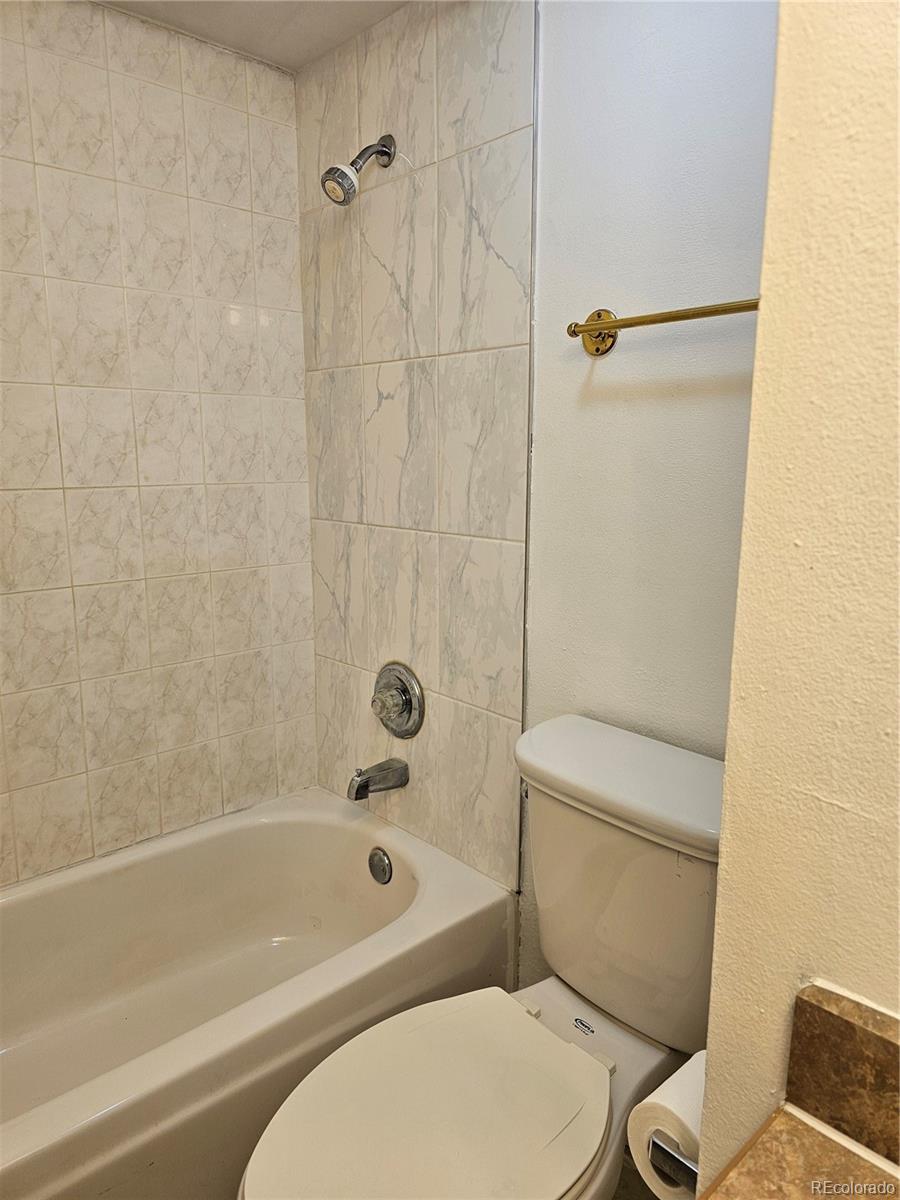1020 15th Street, Unit 33B Denver, CO 80202 - Photo 9 of 48 a white toilet and shower sitting next to a bathroom sink